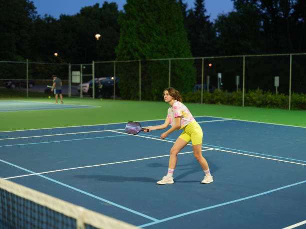 istock Woman playing  singles pickleball at dusk 2183283951