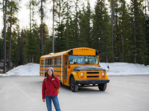 istock Woman near school bus in the forest 2183284568