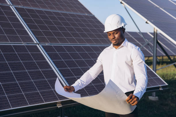 istock African American Engineer Inspecting Solar Panels with Blueprint in Hand 2183286891