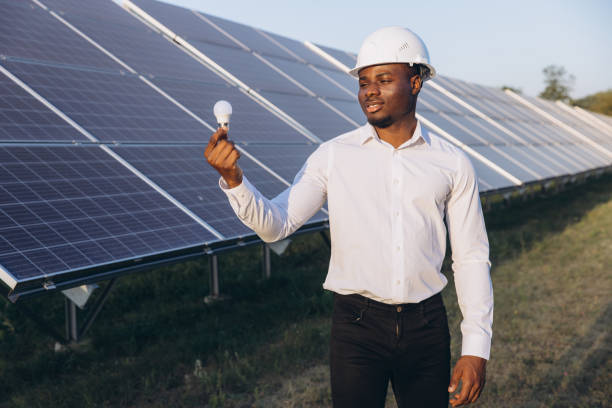 istock African American Engineer Examining Light Bulb Near Solar Panel Installation 2183290073