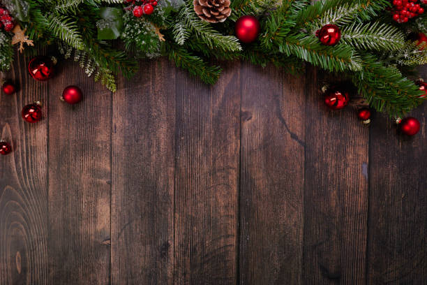 istock Festive Rustic Christmas Background Featuring Red Ornaments and Lush Pine Branches on Wood 2183293338