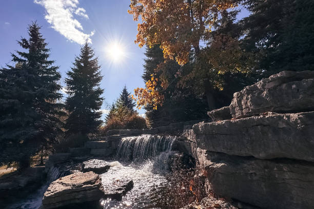 Waterfall in the autumn forest on a sunny day. Nature background.