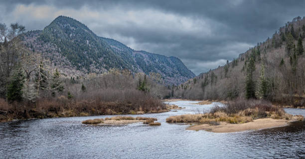 Autumn landscape in the beautiful Jacques-Cartier National Park in Quebec, Canada. Jacques-Cartier National Park offers a magnificent landscape with a vast mountainous plateau fractured by several valleys. The most spectacular is the Jacques-Cartier Valley, it has a trench more than 550 m deep, crossed by a river of the same name, alternately calm and wild. north quebec stock pictures, royalty-free photos & images