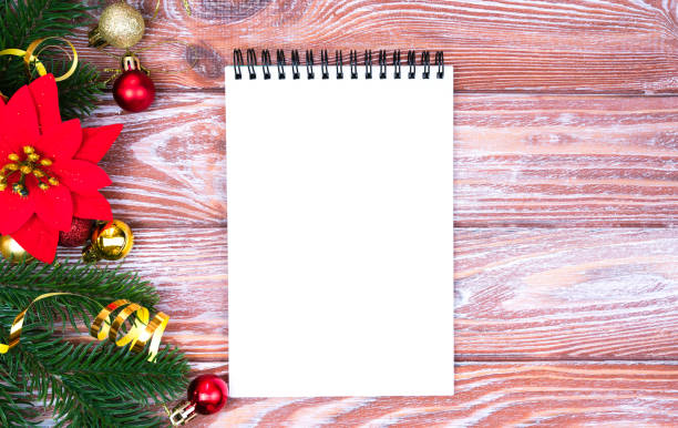 istock Festive Christmas composition with blank notepad for wish list and Christmas decoration on wooden background. Copy space. Flatlay. Top view. 2183295767
