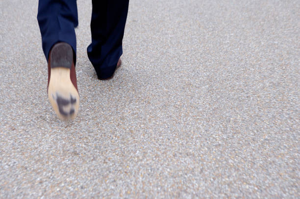 AXTN2R Feet of man walking on street.
