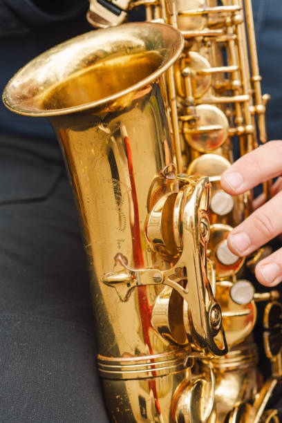 istock A saxophonist performs in a serene park during autumn while seated on a bench 2183298566