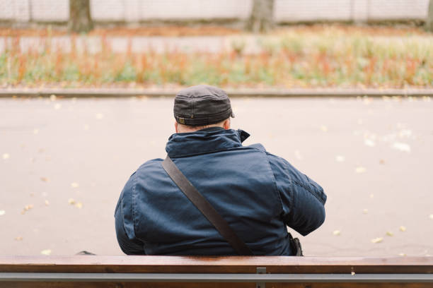 istock A saxophonist performs in a serene park during autumn while seated on a bench 2183298610