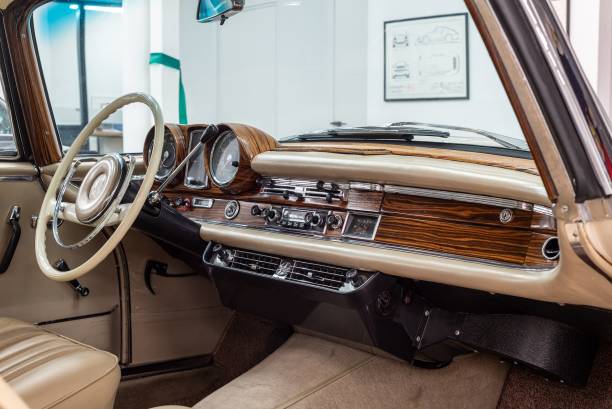 Vilnius, Lithuania - February 7, 2024: Luxury interior of the 1965 Mercedes Benz 250SE Coupe W111, classic luxury coupe by Mercedes Benz. Real wooden trim parts in the dashboard and high quality leather on seats and door panels.