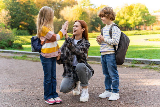istock Volunteer or camp teacher spending time with kids in park 2183303518