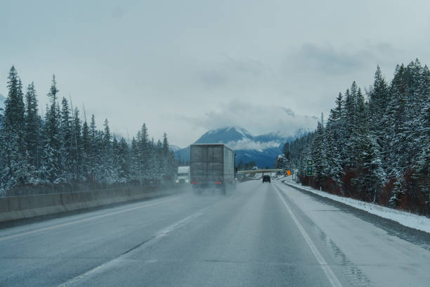 Truck on highway through Banff National Park in   Canadian Rockies in spring. Mountains on the background