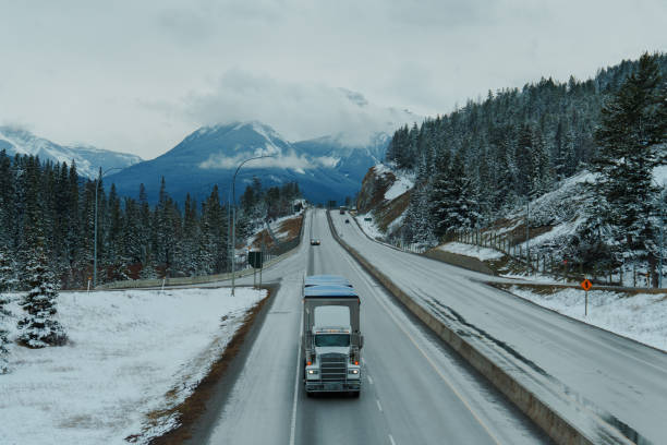 Truck on highway through Banff National Park in   Canadian Rockies in spring. Mountains on the background