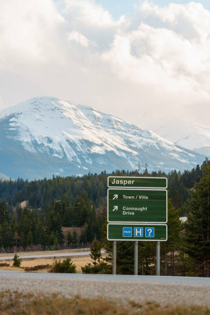 Exit sign to Jasper in Canadian Rockies with snowcapped mountain on the background