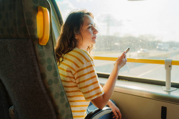 istock Woman using smartphone traveling by bus on sunny day 2183306161