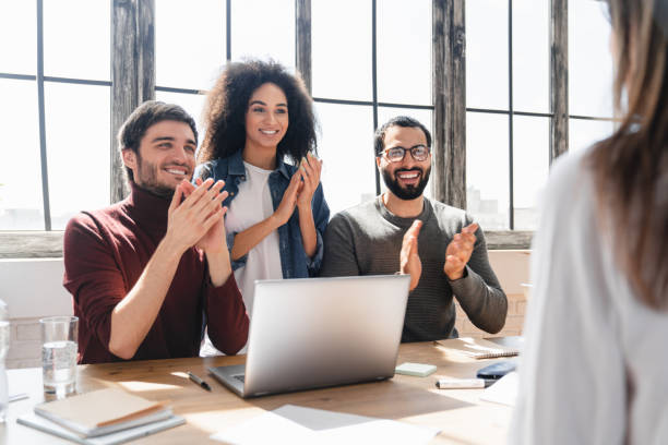 istock Young business woman sharing creative ideas a meeting in a modern office while others are applauding 2183308434