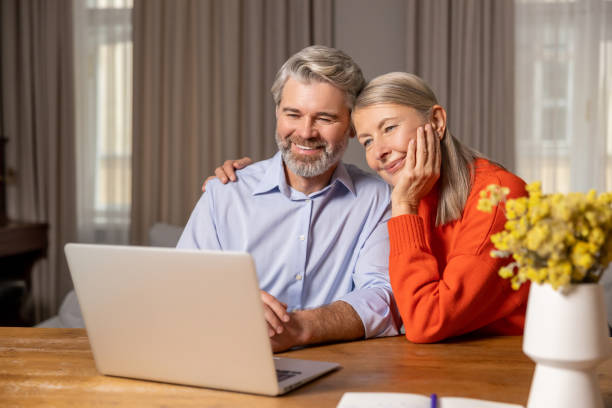 istock Smiling mature couple having a video call and looking involved 2183310106