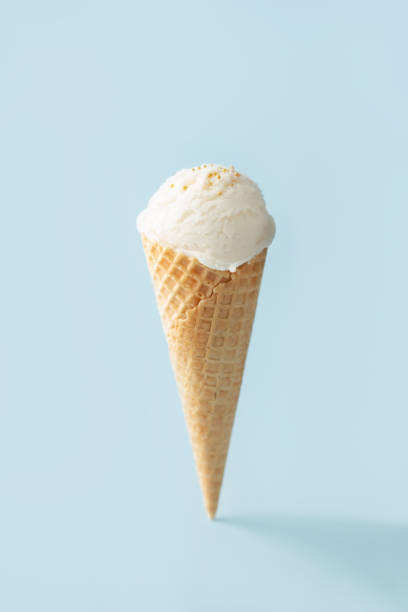 istock Vanilla ice cream ball in a waffle cone on a blue background 2183311557