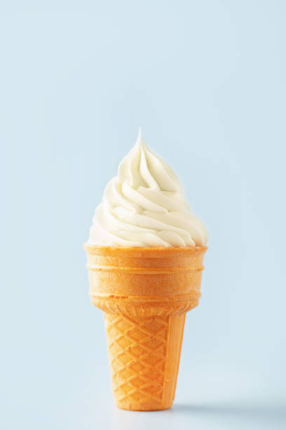 istock Vanilla soft ice cream ball in a waffle cone on a blue background 2183311571