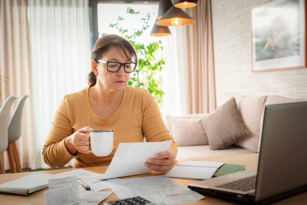 istock Woman reading documents and calculating home finances 2183317009