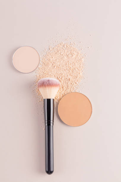 istock Two blocks of refill compact powder of different tones on a beige background with a professional makeup brush. dry sample of natural powder. vertical 2183322680