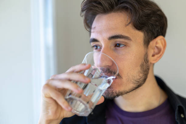 istock Handsome young man drinking water from a water glass 2183325916