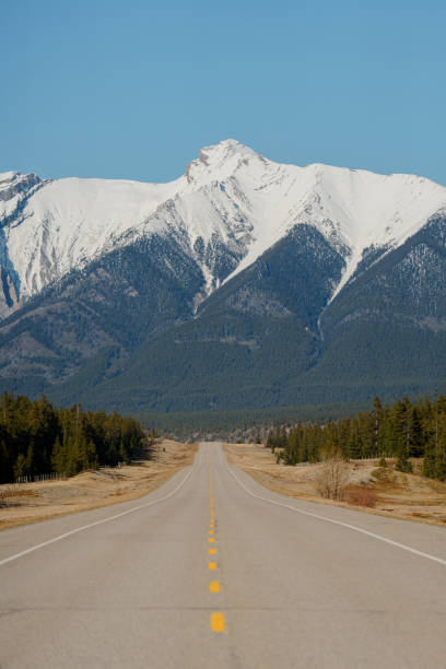istock Road through Canadian Rockies with mountains covered in snow 2183326129