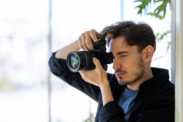 istock Young man takes photos with mirrorless camera 2183326849