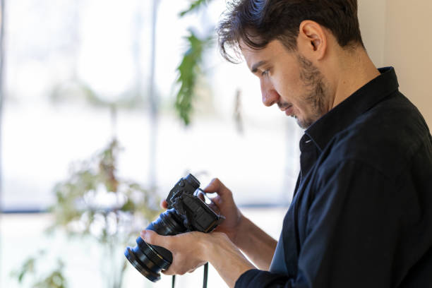 istock Young man takes photos with mirrorless camera 2183326881