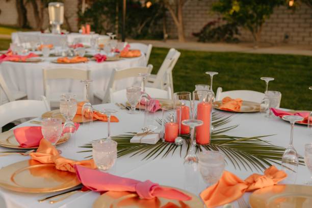 Wedding table decorated with red and orange accents and a white tablecloth
