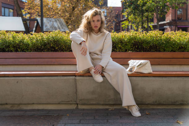 istock Women sits on bench in autumn day 2183333508