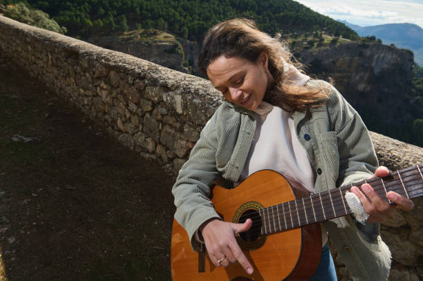 istock Woman joyfully playing guitar in scenic mountain setting 2183336055