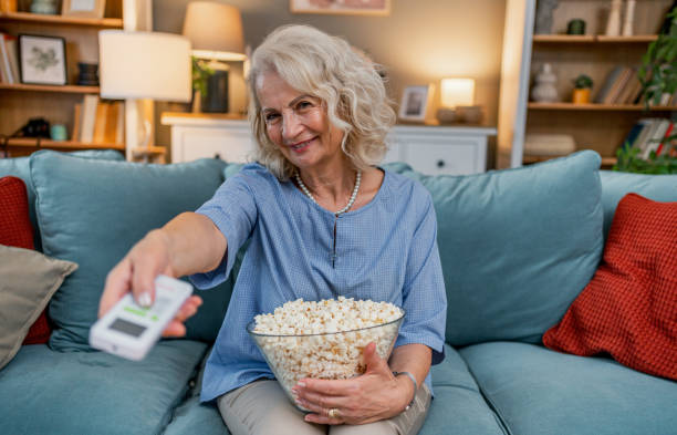 istock Senior woman watching tv at home 2183336622
