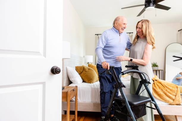 istock Senior man stands with help from wife and mobility walker 2183345445