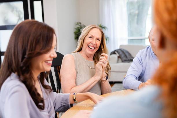 istock Mature mom laughs with young adult daughters during visit 2183345450