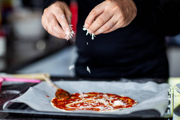 istock Man adding cheese to pizza Margherita with hands 2183346274