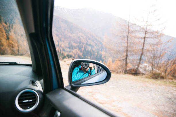 Photographer captures reflection in car mirror during mountain drive