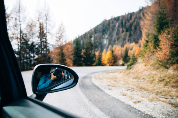 istock Photographer captures scenic autumn road from car mirror reflection 2183346311