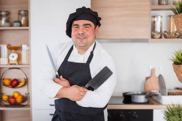 istock Proud chef standing and holding a knife and cleaver 2183359698