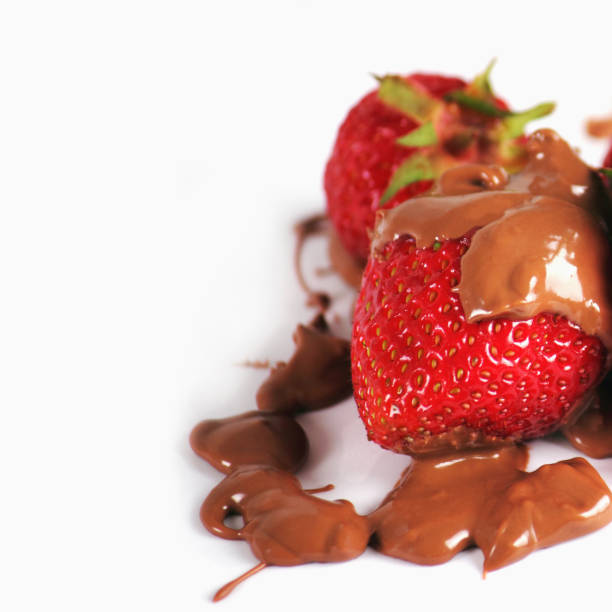 Strawberries in chocolate against white background. Delicious food