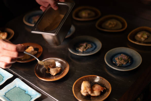 istock Chef Preparing Plating Group of Fresh Dishes On Small Plates Garnishing with Sauce 2183379583