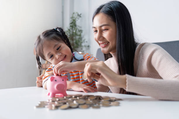 istock Parent and Child Engaged in Saving Activity with Piggy Bank 2183384929