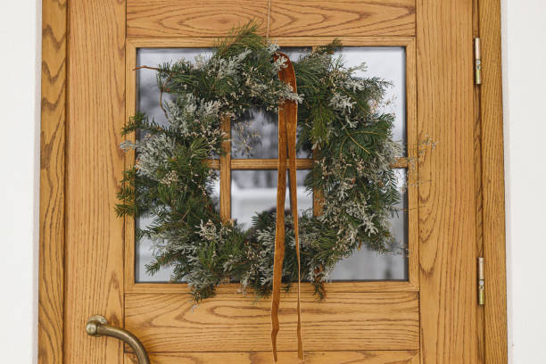 istock Stylish christmas rustic wreath with ribbon hanging on front doors, close up. Modern house entrance or porch decoration for winter holiday. Merry Christmas and Happy holidays 2183402206