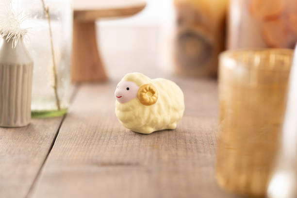 In a cozy hotel room, a soft plush sheep rests serenely on a crisp white bedsheet, embodying comfort and charm. The room exudes a tranquil atmosphere, perfect for relaxation after a day of travel or exploration. The plush toy, with its fluffy wool and gentle demeanor, adds a touch of whimsy and warmth to the neatly arranged bedding. Set against a backdrop of muted décor and soft lighting, the scene invites a sense of peaceful retreat, where the plush sheep becomes a delightful companion in this serene setting.