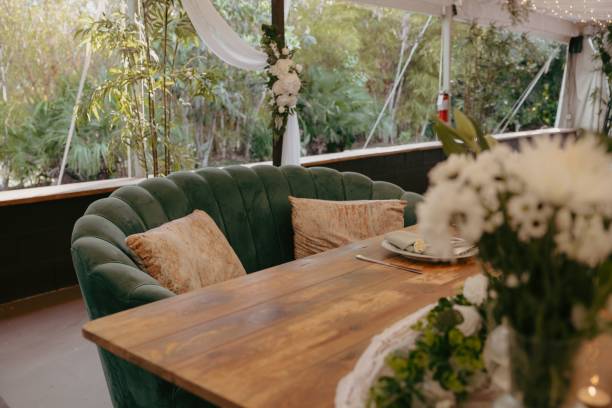 istock Small, intimate dining area with a curved, emerald green sofa and a wooden table. 2183409609