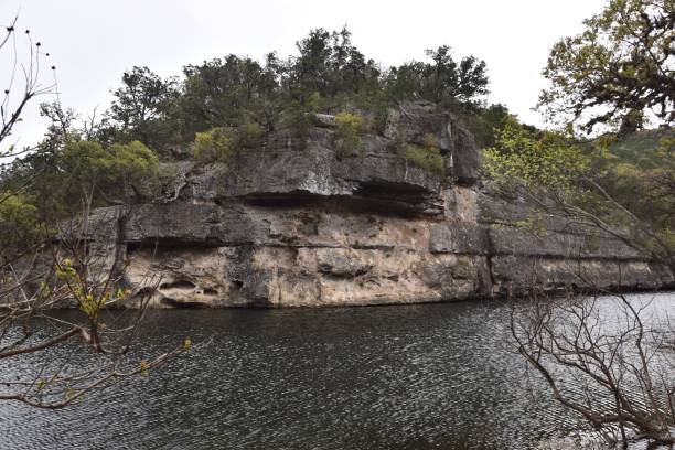 istock Reflecting stream by rocky cliff with forest trees in Lost Maples State Park, Texas 2183409813