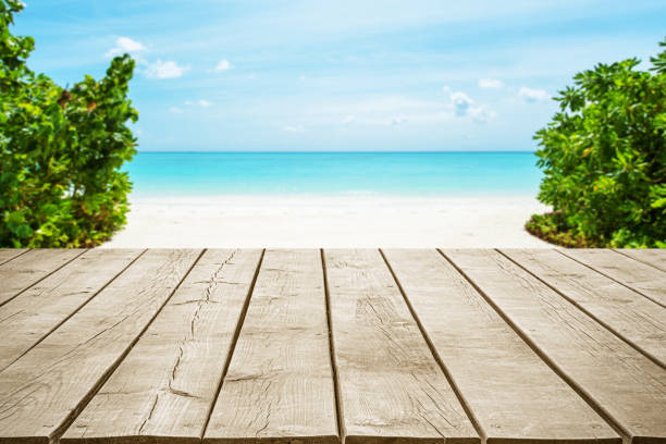 Empty wooden table top with beautiful tropical paradise beach background