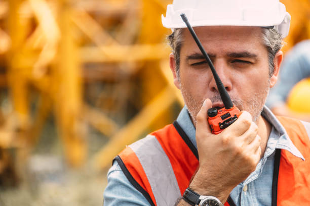 istock Italian worker engineer construction site control radio operation. Foreman operate crane tower working order by walkie talkie. 2183415208
