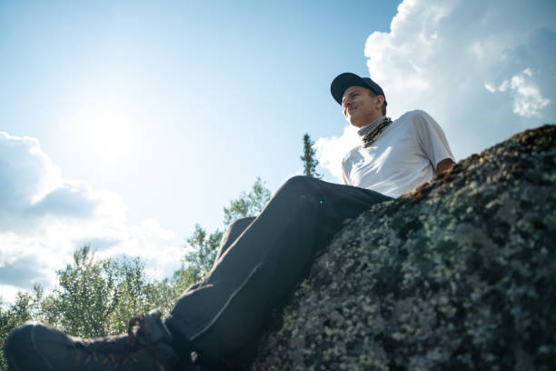 Man Relaxing on a Rock Underneath a Clear Sky Outdoors