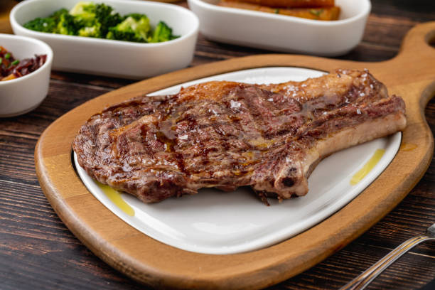 istock Grilled veal chop on white porcelain plate on wooden table 2183417809