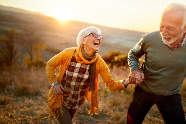 istock Cheerful mature couple having fun on a hill at sunset. 2183419480