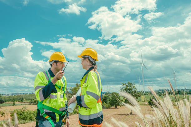 istock Engineer team man and women workers Wind Turbines service team working together at wind electricity generator farm field. 2183419654